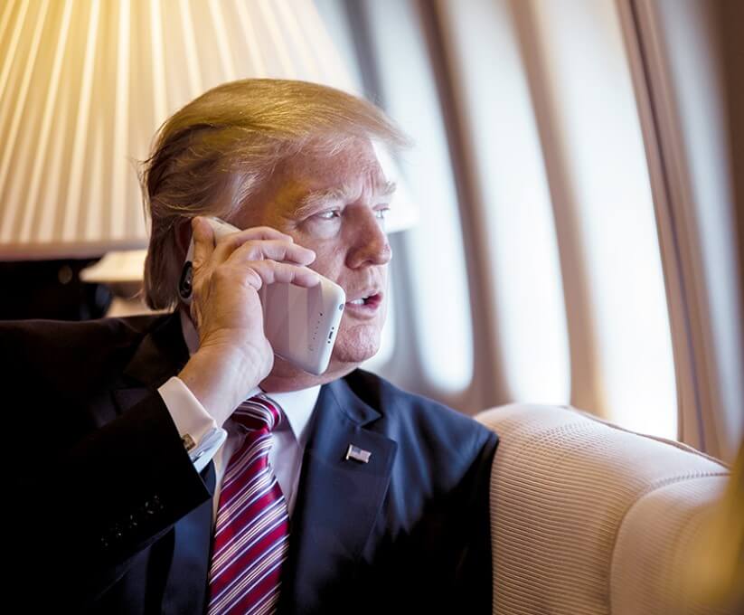 President Donald Trump talks on the phone aboard Air Force One during a flight.